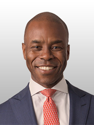 Denver Edwards in a navy suit, white shirt and light red tie