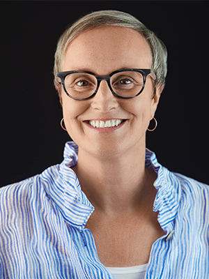 Sue Kavanaugh in a ruffled blue-and-white-striped shirt