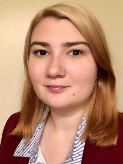 Photo of Gabrielle Juers - a woman with shoulder length hair, wearing a collared shirt and maroon blazer, smiling