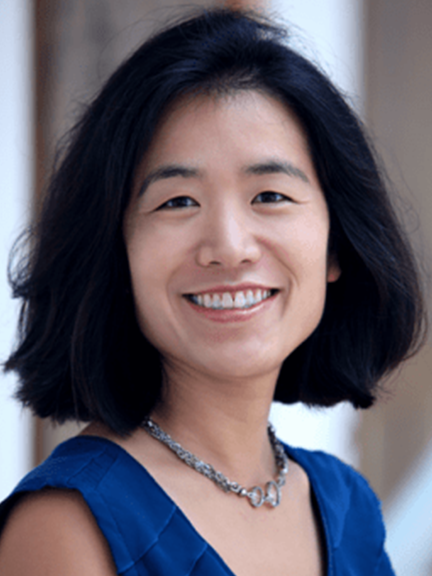 Portrait of Linae Ishii-Devine wearing a blue blouse and green necklace.