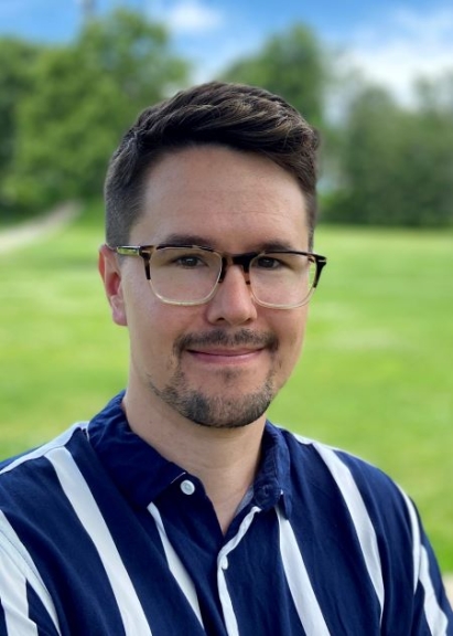 Man with glasses and striped blue and white shirt.