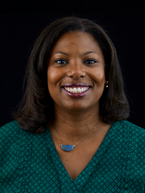 Danielle Wells headshot in green patterned blouse