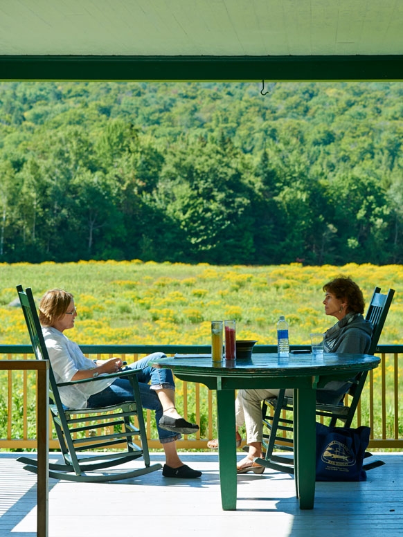 Two writers discussing work on the porch of the Bread Loaf Inn.