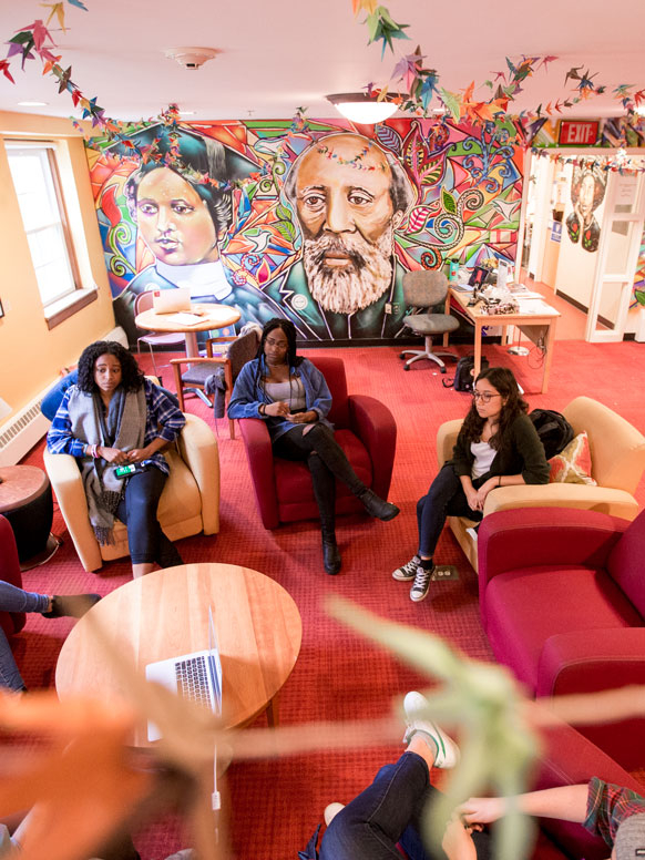 Students talking and sitting on couches and in chairs around the AFC.