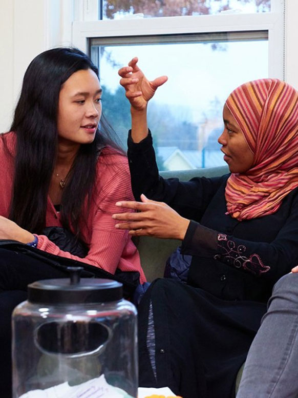 Two students of differing ethnic backgrounds talking together.