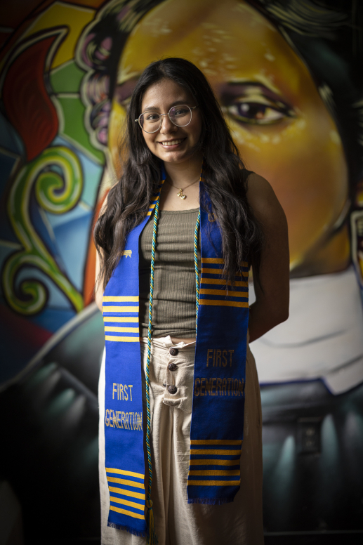 Female student standing in front of a mural