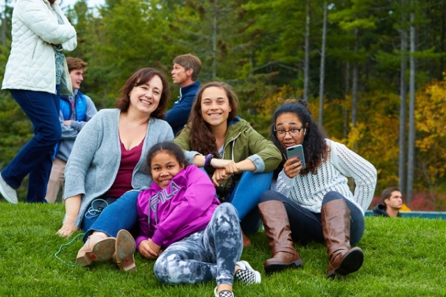 family with kids sitting on grass