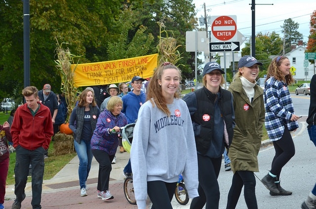 smiling people walking in front of CROP Hunger Walk banner