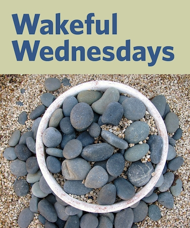 white dish with grey stones on sand