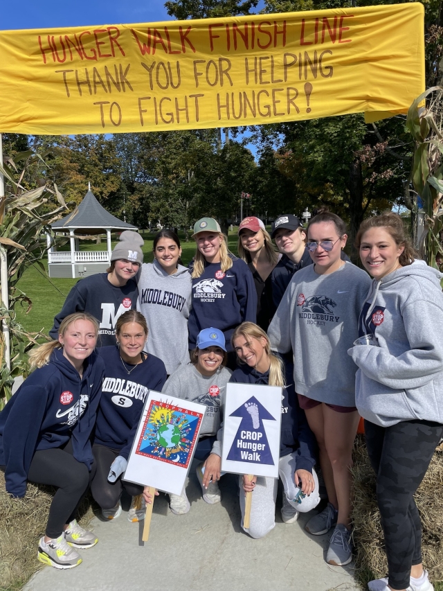 ten college hocket players beneath CROP Walk finish line banner