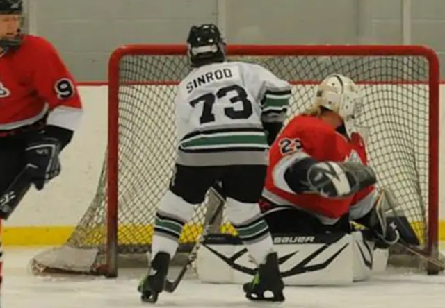 Middlebury Alumna Linda Sinrod playing ice hockey and scoring a goal