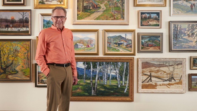 Lyman Orton ’63 posing in front of artwork