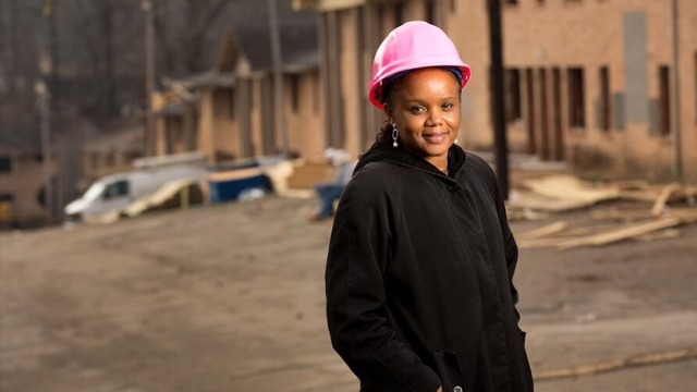 Portrait of Roshun Austin '93 in a pink hard hat and black jacket