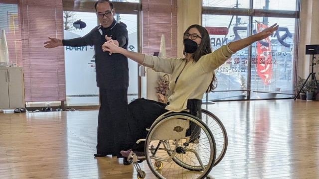 Aubrianna Wilson ’23 posing on a dance floor while seated in her wheelchair
