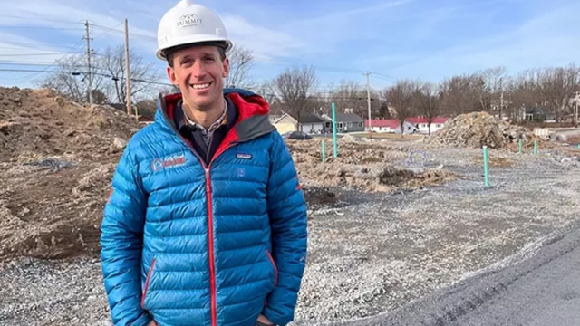 Zeke Davisson ’08 Standing in front of contruction site wearing a hard hat