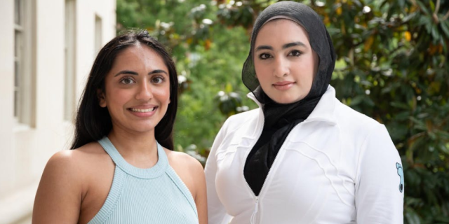 Urvi Patel and Khizra Ahmad pose for a portrait outside a library.