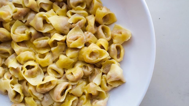 Top-down view of pasta in white bowl on marble counter