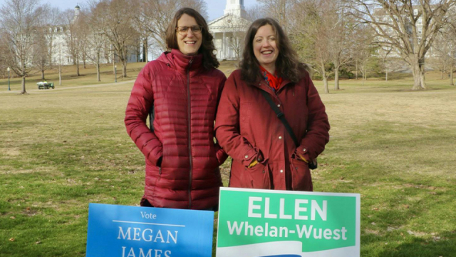 Megan James ’05.5 and Ellen Whelan-Wuest ’05.5 standing in behind their election signs
