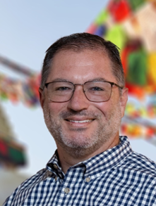 headshot of person in glasses smiling