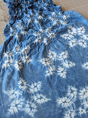 Detail of indigo-dyed shibori fabric patterned with undyed white asanoha pattern