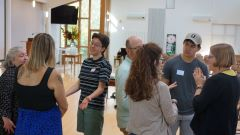Students and faculty standing, talk in groups