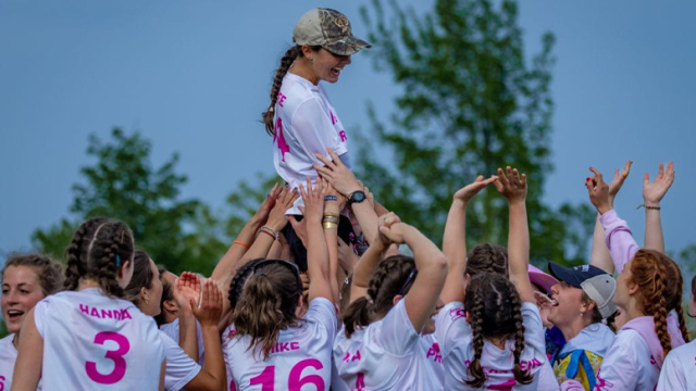 Middlebury Prankster lifting teammate above head while cheering