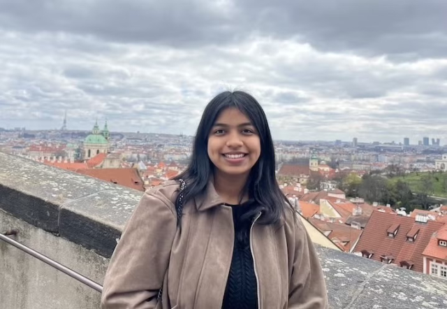 Person standing outside looking at the camera and smiling.