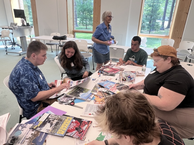 People sitting around a table working with crafting supplies
