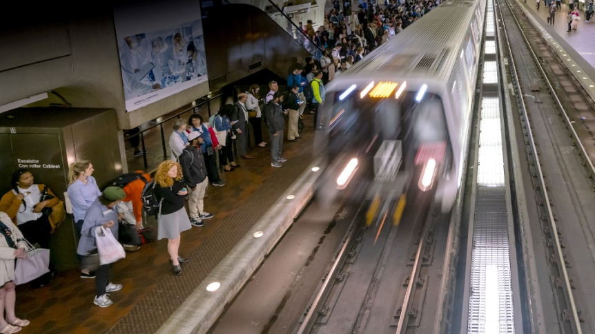 People wait along the track at a Washington DC metro station.