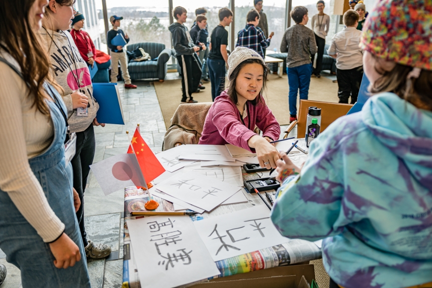 A Middlebury student shares calligraphy techniques with local 5th graders