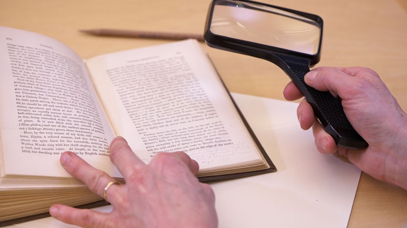 Close up of an ancient text and a magnifying glass.