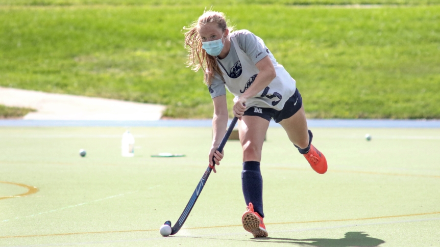 A Middlebury field hockey player practices wearing a mask.