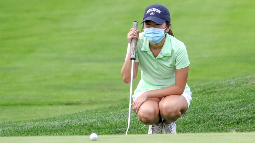 A Middlebury golf player looks at a putt during practice.
