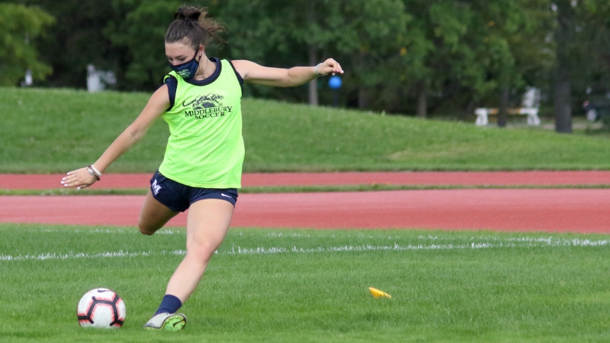 A Middlebury soccer player practices while wearing a mask.