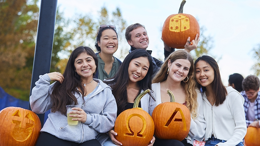 Six Middlebury students pose with carved pumpkins.