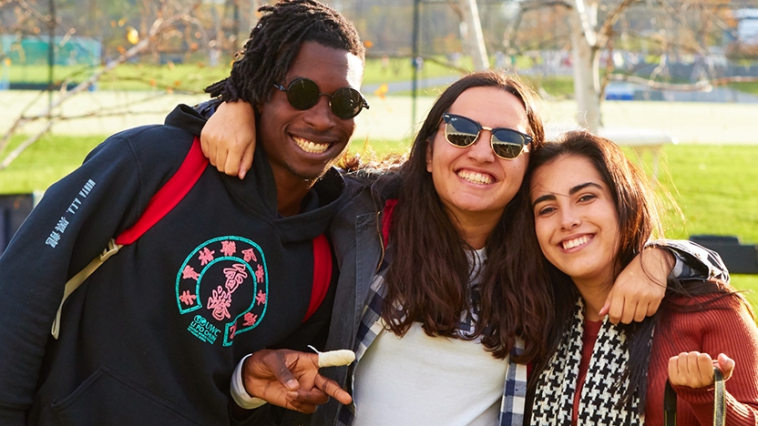 Three Middlebury students pose for a photo outdoors during Harvest Fest