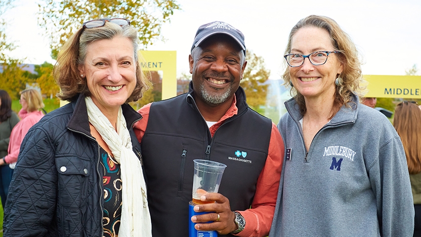 Middlebury alumni and staff posse for a photo outdoors at Harvest Fest