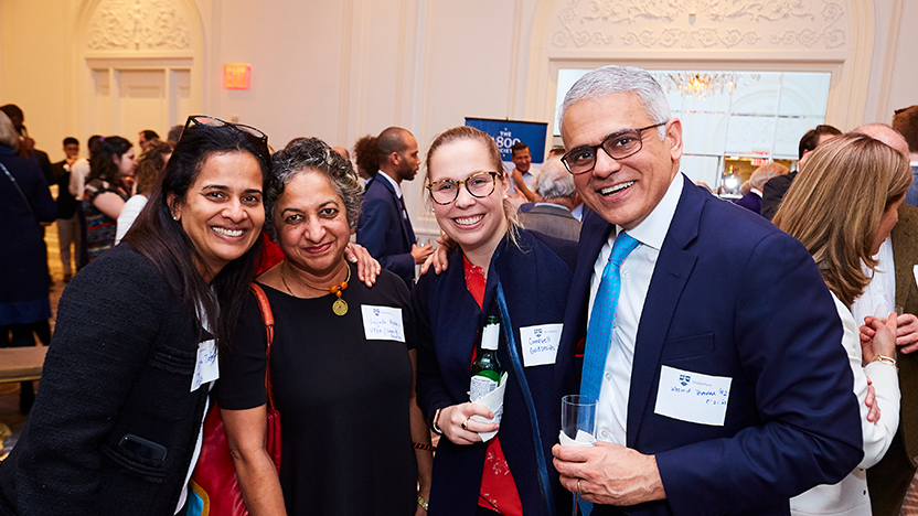 Four smiling attendees at the NYC 1800 Society holiday party