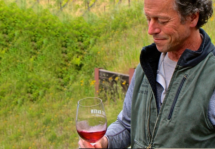 Portrait of Bradley Brown holding a glass of red wine