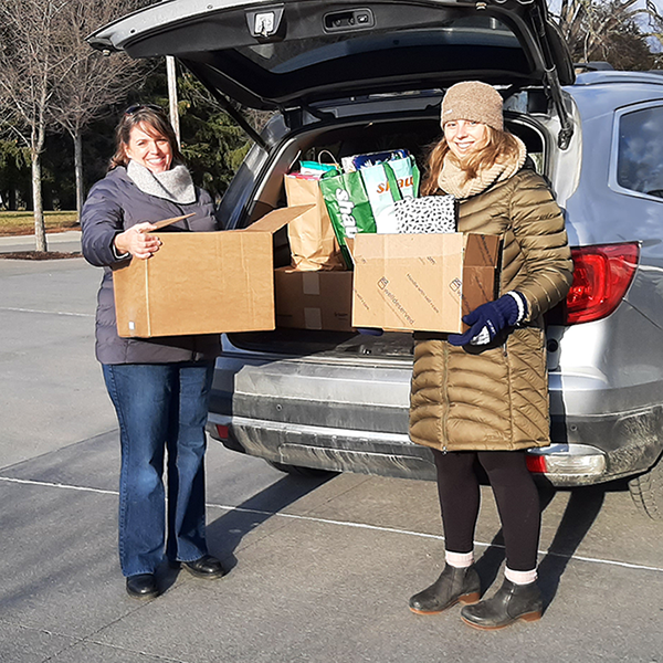 Two people loading boxes of food in car