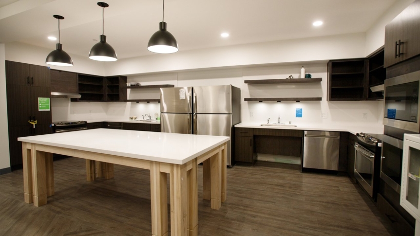 A kitchen space with multiple sinks, ovens, and refrigerators