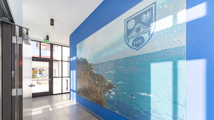 An indoor hallway with a mosaic showing the California coast