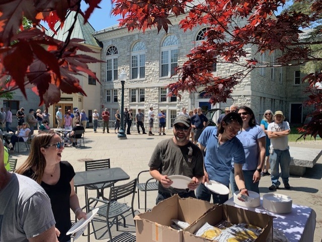 Picture shows staff members lined up to eat and laughing