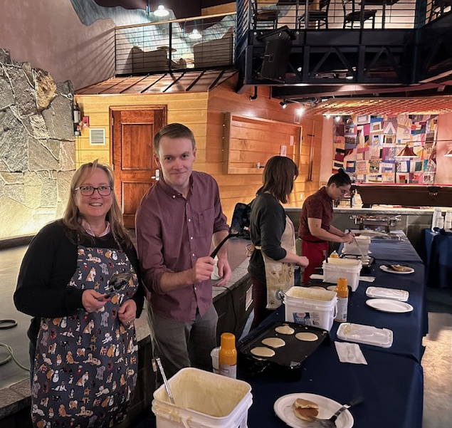 Photo of Staff members serving pancakes