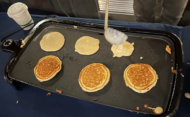Photo of Staff members serving pancakes