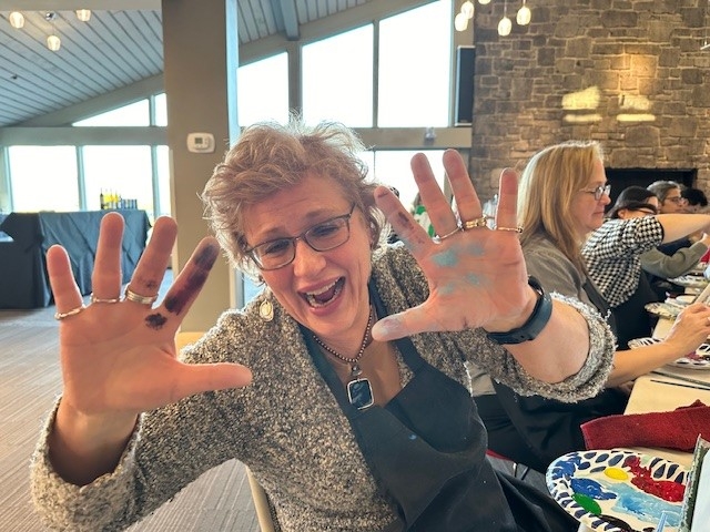 Participant showing her fingers covered in paint