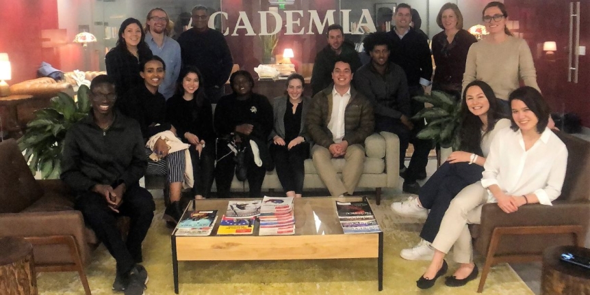 10 Middlebury students with CCI Advisors seated in the Academia lobby with VP of Communications Adi Raval '98