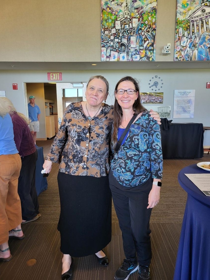 The President of Middlebury College standing smiling with a colleague.