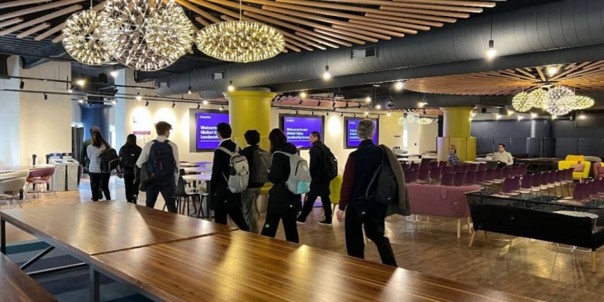 A group of students walk through the Wayfair lobby.