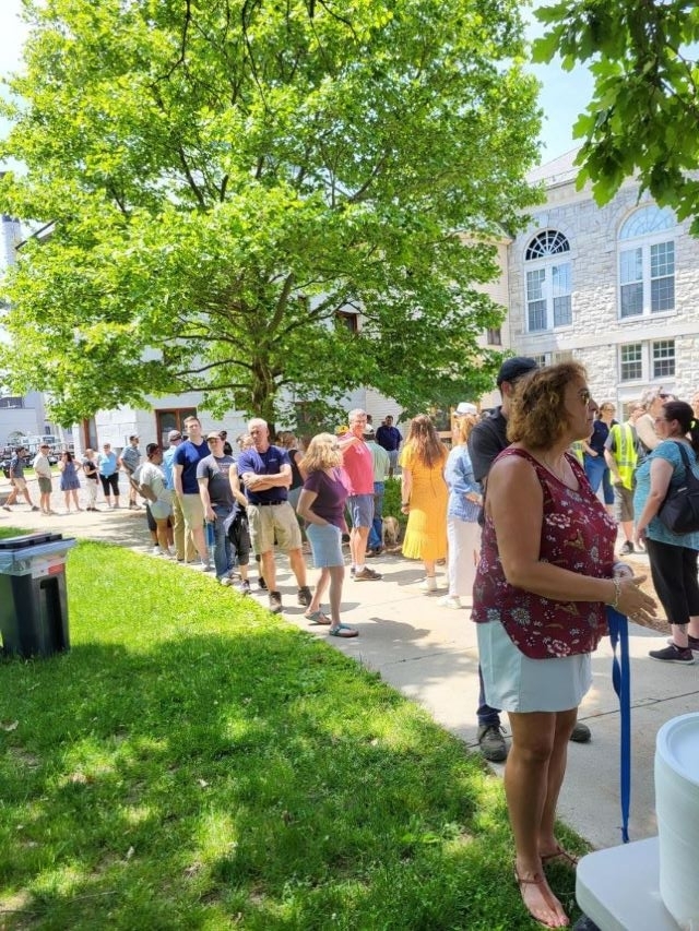 Employees Standing in line in the sun waiting for BBQ line